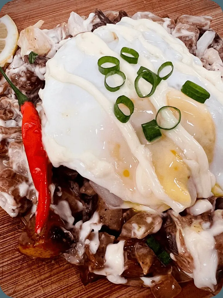 Sisig topped with a fried egg over rice